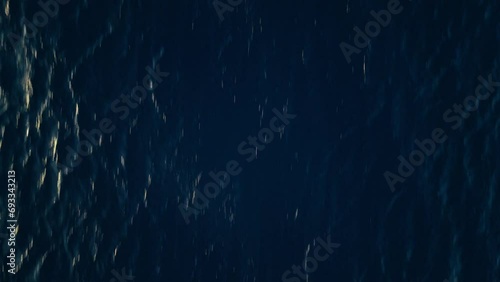 Sunlight glistens and glints across deep blue ocean water, nature background photo