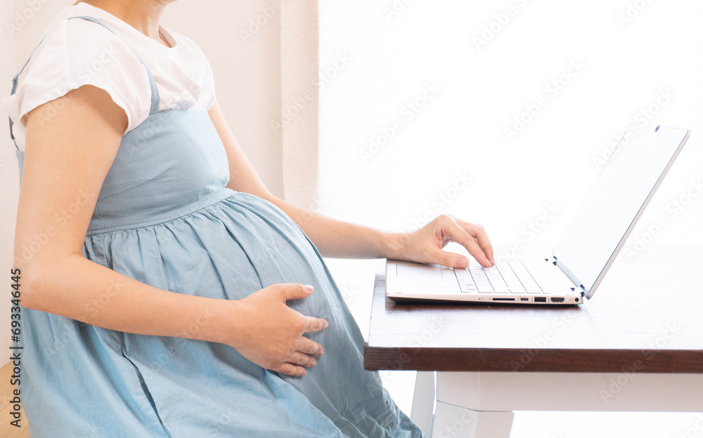 Naklejka premium Asian pregnant woman joins online business meeting and talks to customers on video call.
