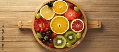 View from above, Fresh Fruit Slices on a Wooden Plate neatly arranged
