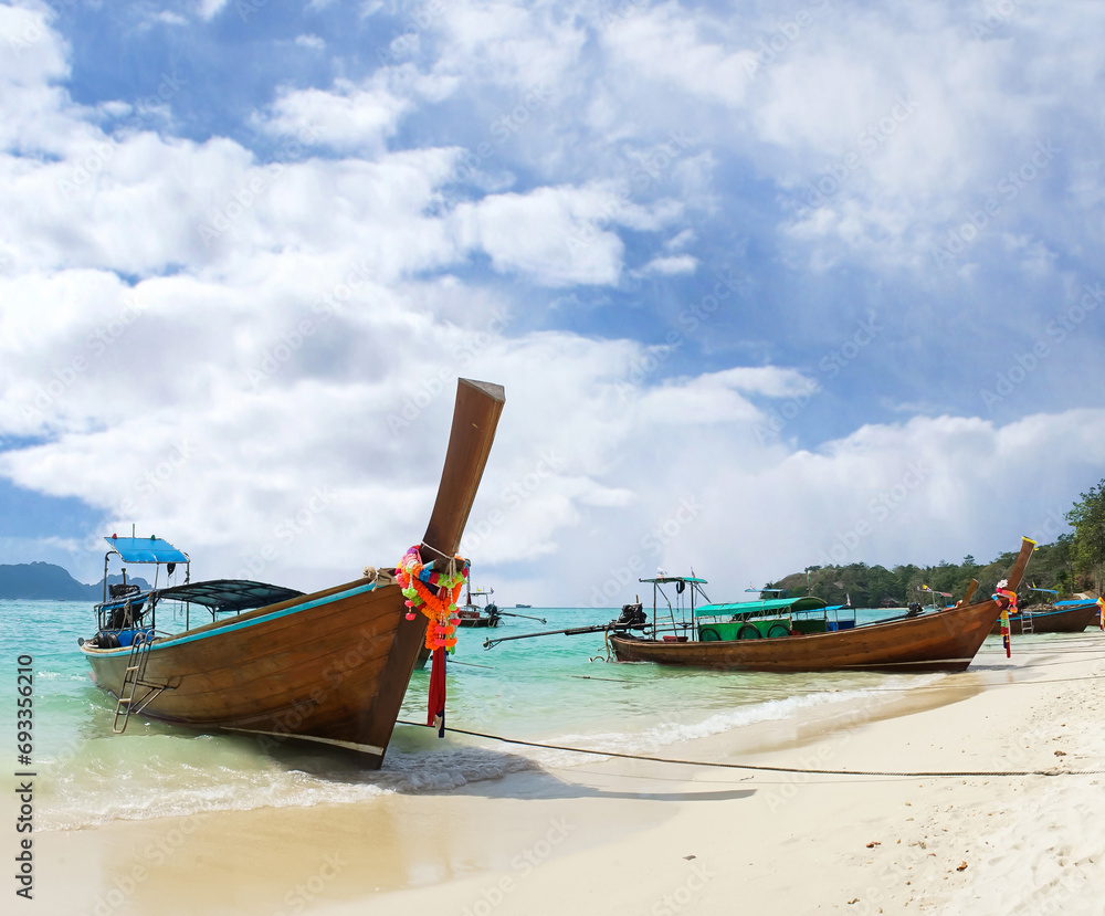 Thai traditional wooden longtail boat and beautiful sand beach in Thailand. Traveling concept. Thai traditional wooden longtail boat and beautiful sand beach in Thailand. Traveling concept.