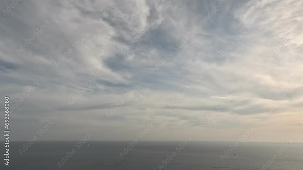 Timelapse fluffy Cumulus clouds moving in bright sunset sky over calm sea. Abstract aerial nature summer ocean sunset, sea and sky view. Vacation, travel, holiday concept. Weather and Climate Change Timelapse fluffy Cumulus clouds moving in bright sunset sky over calm sea. Abstract aerial nature summer ocean sunset, sea and sky view. Vacation, travel, holiday concept. Weather and Climate Change