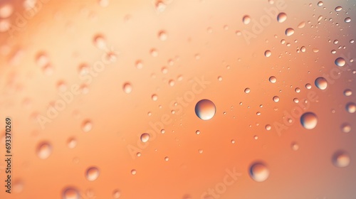 Drops of water, dew or rain on a peach-colored background.