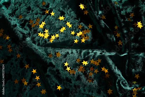 Abstract Christmas background with gold stars on a green velvet background. photo