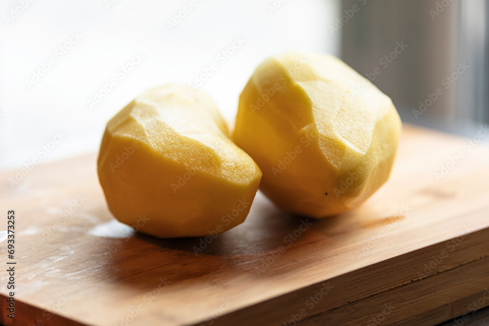 Two Peeled Potatoes on Wooden Board Close-Up 
