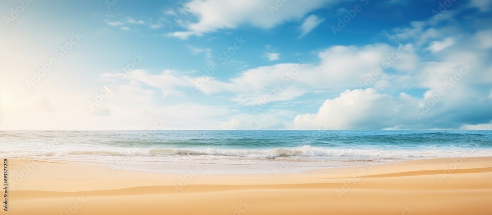 Summer beach blur defocused background. tropical with golden sand, turquoise ocean blue sky with white clouds on bright sunny landscape for holidays product presentation.