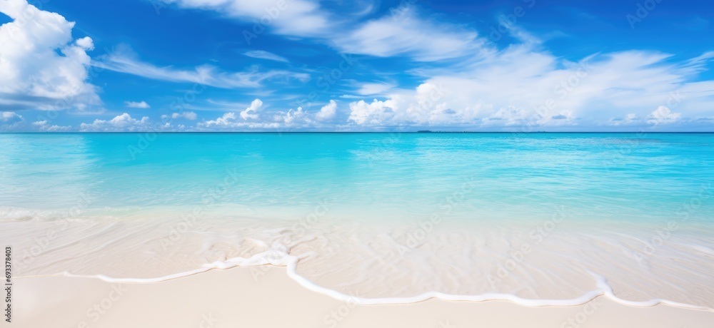 Summer Sandy beach with white sand and rolling calm wave of turquoise ocean on white clouds in blue sky. Island, landscape