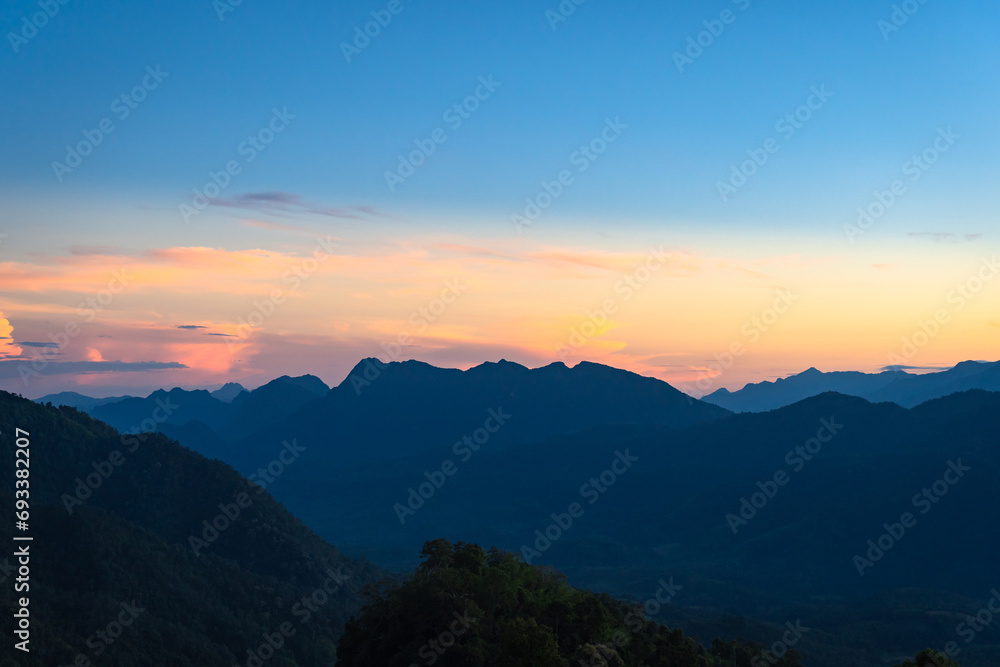 Beautiful natural scenery mountain peaks in the sunset on the hills and the Thai language on the sign means Glo Selo Viewpoint at Mae Hong Son, Thailand. Space for Background Wallpaper concept.