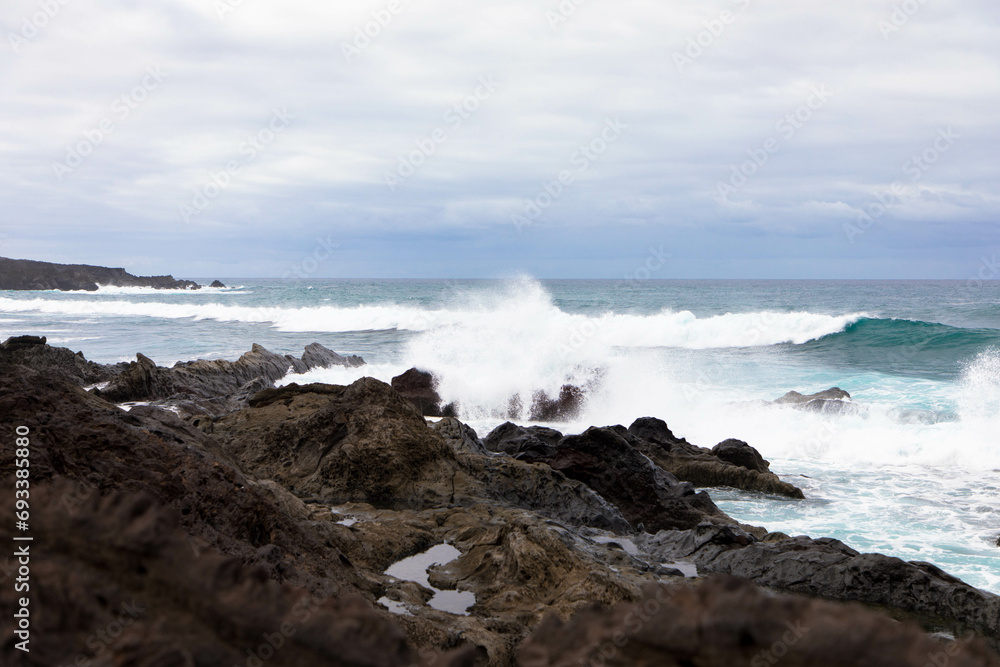 Panoramic view of Playa El Golfo volcanic beach and rocky coast on a windy day. Seen from the Charco de los Clicos viewpoint. Lanzarote, Canary Islands, Spain Panoramic view of Playa El Golfo volcanic beach and rocky coast on a windy day. Seen from the Charco de los Clicos viewpoint. Lanzarote, Canary Islands, Spain