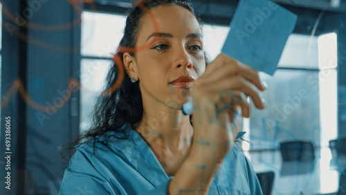 Young hispanic employee writing on colorful sticky notes. Smart businesswoman sharing marketing idea, brainstorming strategy, business plan. Project manager drawing mind map. Closeup. Manipulator.