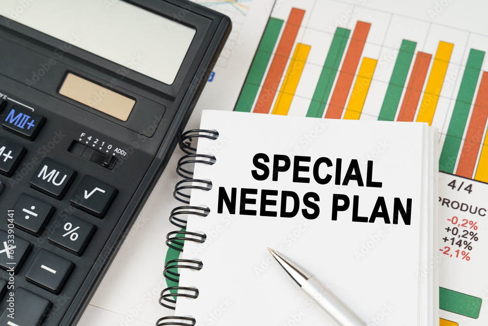 On business charts there is a calculator, a pen and a notepad with the inscription - special needs plan On business charts there is a calculator, a pen and a notepad with the inscription - special needs plan