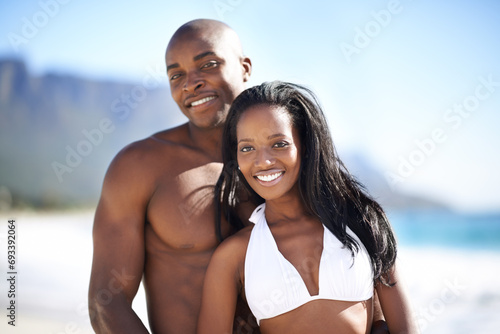 Happy, bonding and portrait of black couple at the beach for valentines day vacation, holiday or adventure. Smile, love and African man and woman on date by the ocean or sea on weekend trip together.