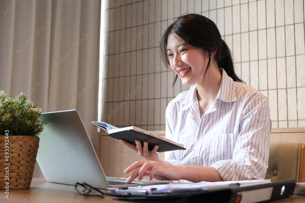 Asian Businesswoman working on laptop at the office with documents on his desk, doing planning analyzing the financial report, business plan investment Asian Businesswoman working on laptop at the office with documents on his desk, doing planning analyzing the financial report, business plan investment