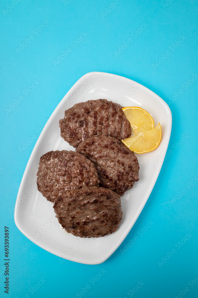 fried cutlet for burger with lemon. In a white plate fried cutlet for burger with lemon. In a white plate