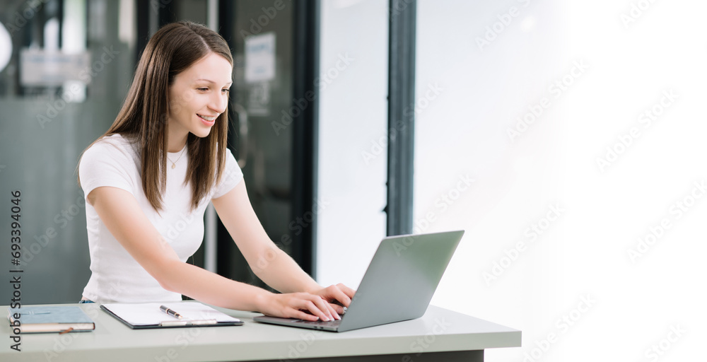 Confident woman with a smile standing holding notepad and tablet at the office.