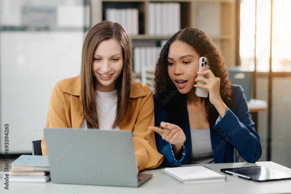 Two business workers talking on the smartphone tablet and using laptop at office... Two business workers talking on the smartphone tablet and using laptop at office...
