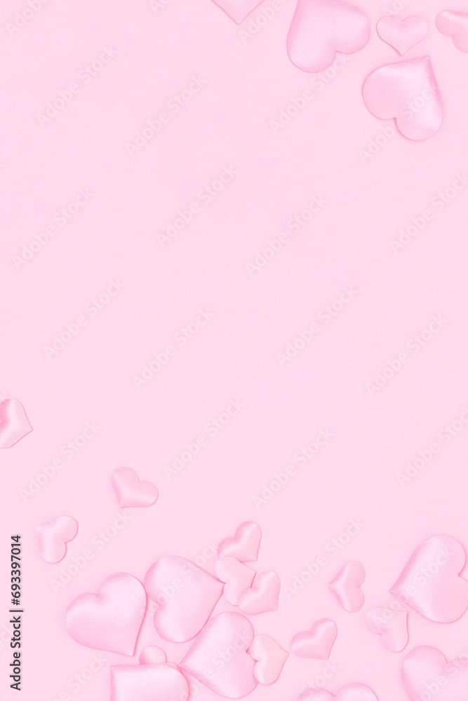 Hearts confetti scattered on a pink background. Festive concept with copy space.
