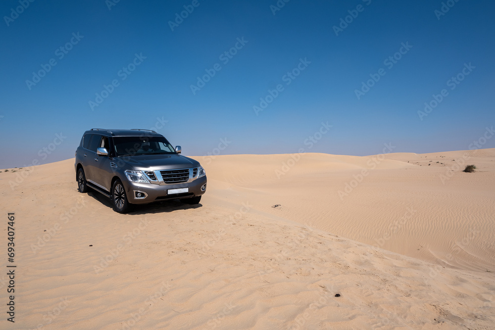 SUV four wheel drive vehicle car Al Qudra empty quarter seamless desert sahara in Dubai UAE middle east with wind paths and sand hills gray cloudy sky SUV four wheel drive vehicle car Al Qudra empty quarter seamless desert sahara in Dubai UAE middle east with wind paths and sand hills gray cloudy sky