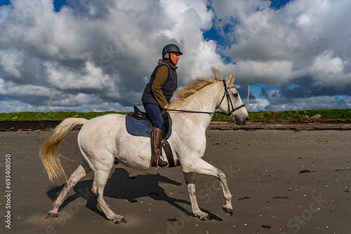 Horse and rider on the beach at low tide
