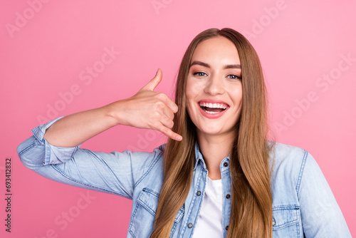 Photo portrait of lovely young lady show hand mobile phone call me gesture dressed stylish denim garment isolated on pink color background