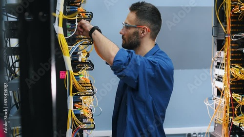 Server technician putting UTP cable into crimping pliers photo