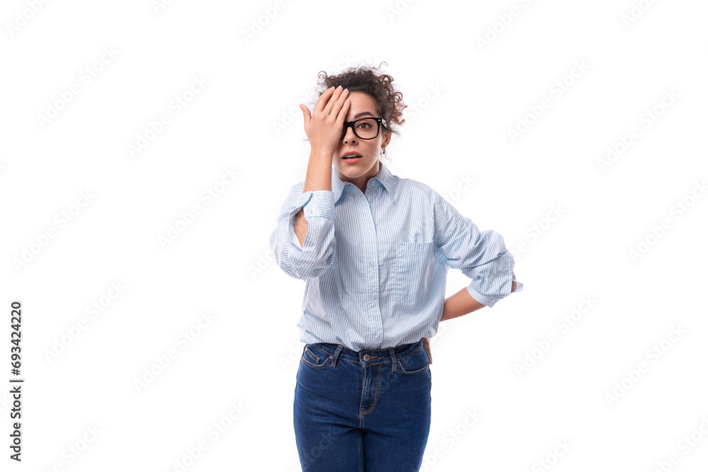 young slender curly brunette assistant woman dressed in a light blue shirt wears glasses for vision young slender curly brunette assistant woman dressed in a light blue shirt wears glasses for vision