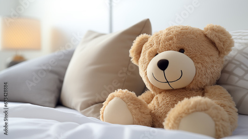 Adorable beige teddy bear, sitting in white bed, at daylight