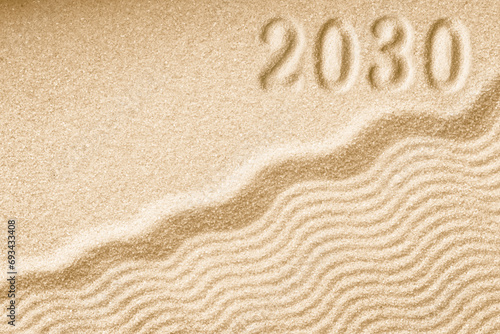 Imprints of numbers 2030 new year on a golden sand waves