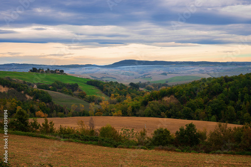 The picturesque authentic Italian landscape with villa, cypresses and plowed field in Tuscany, Italy. photo