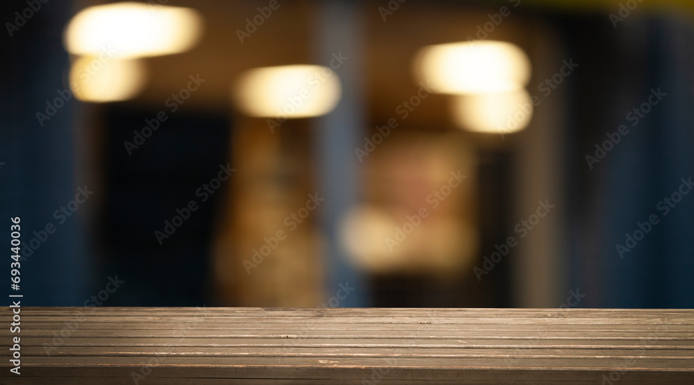Empty wooden table top on blur light golden bokeh of cafe restaurant, bar in a dark background. Empty wooden table top on blur light golden bokeh of cafe restaurant, bar in a dark background.