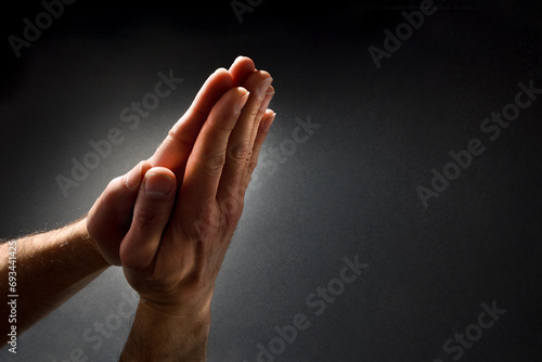 Praying man hands with palms together isolated dark photo