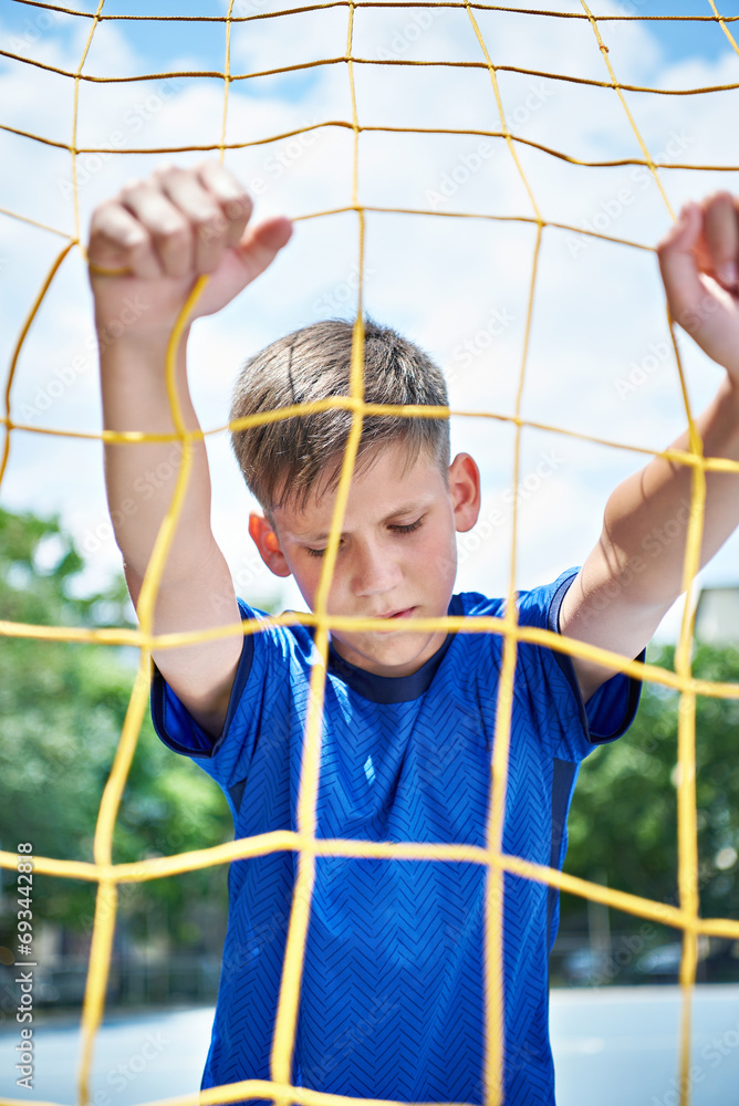 Boy soccer player at the soccer goal net Boy soccer player at the soccer goal net