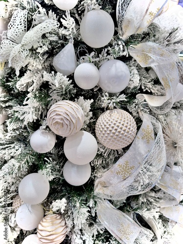 white snow christmas tree decorations detail with baubles balls and glitter festive white ribbon