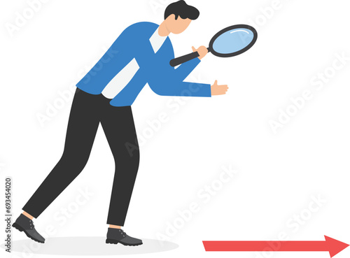 Searching for business direction, strategy or discovering business opportunity or solution for work difficulty concept, businessman leader using magnifying glass to discover an arrow on the floor.

