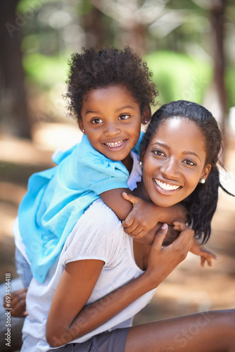 Child, happy mother in portrait and piggyback outdoor, care or bonding together. Face, African mom carrying kid and smile in nature, family play in forest or park, love of parent and summer vacation