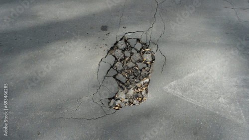 Принти на полотні The road asphalt is cracked and destroyed with holes
