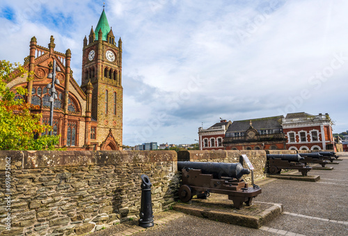 The Guildhall in Derry-Londonderry, Northern Ireland, built in the 19th century with red bricks and the clock tower, meeting place of the local city council, seen from the walls. photo