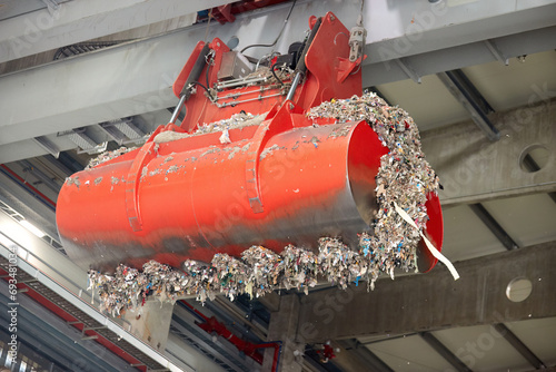 Detalied view of jaws of red grab. Handling and Transportation of fuel obtained from waste (RDF) by red grab to the boiler for combustion.  Processing of municipal solid waste into an energy source. photo