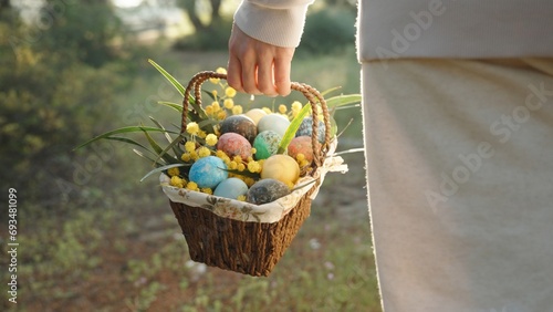Cinematic Frame of Sunbeams Through the Trees, and a Woman in White with a Basket of Easter Eggs Walking Towards Them, Strolling through the Forest.