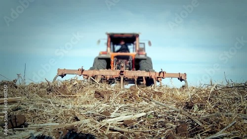 Tractor Plowing in the Field. Low Angle View. 