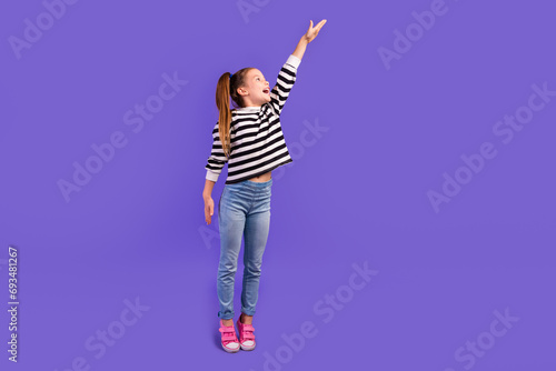 Full length photo of funky impressed little child dressed striped pullover showing arm empty space isolated purple color background