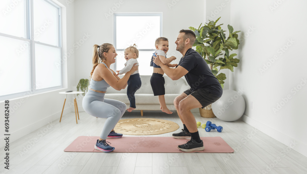 Fototapeta premium Portrait of happy healthy fit young family with little children standing together