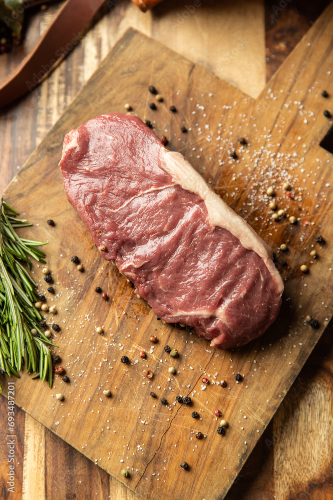 raw New York strip with peppercorns and rosemary raw New York strip with peppercorns and rosemary