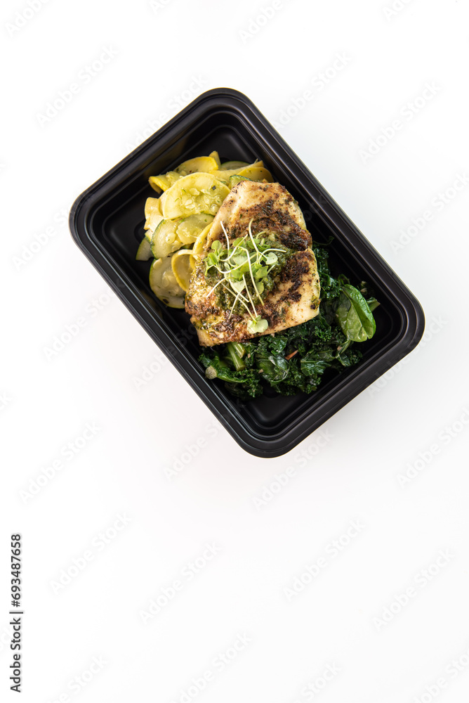 Catered meal in a black container on a white background Catered meal in a black container on a white background