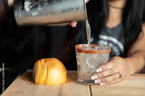 Bartender, with a dark background, pouring a drink © JC_ThroughTheLens