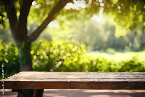 Rustic wooden table in nature. Blank board for summer and spring creations surrounded by greenery and bathed in sunlight