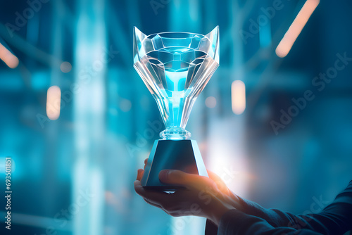 Winner's glass award trophy cup in hand with bright illumination