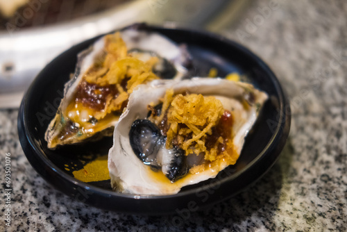 Fresh Oyster in shell topping with fried shallot, chili paste. Thai seafood style concept