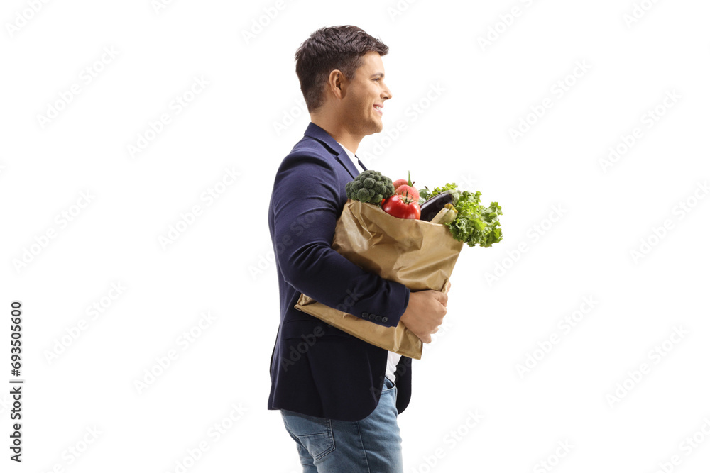 Profile shot of a man carrying a paper bag with groceries Profile shot of a man carrying a paper bag with groceries