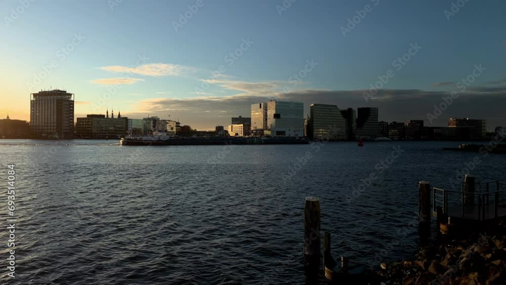 Skyline with modern buildings at river IJ at sunset in Amsterdam Skyline with modern buildings at river IJ at sunset in Amsterdam