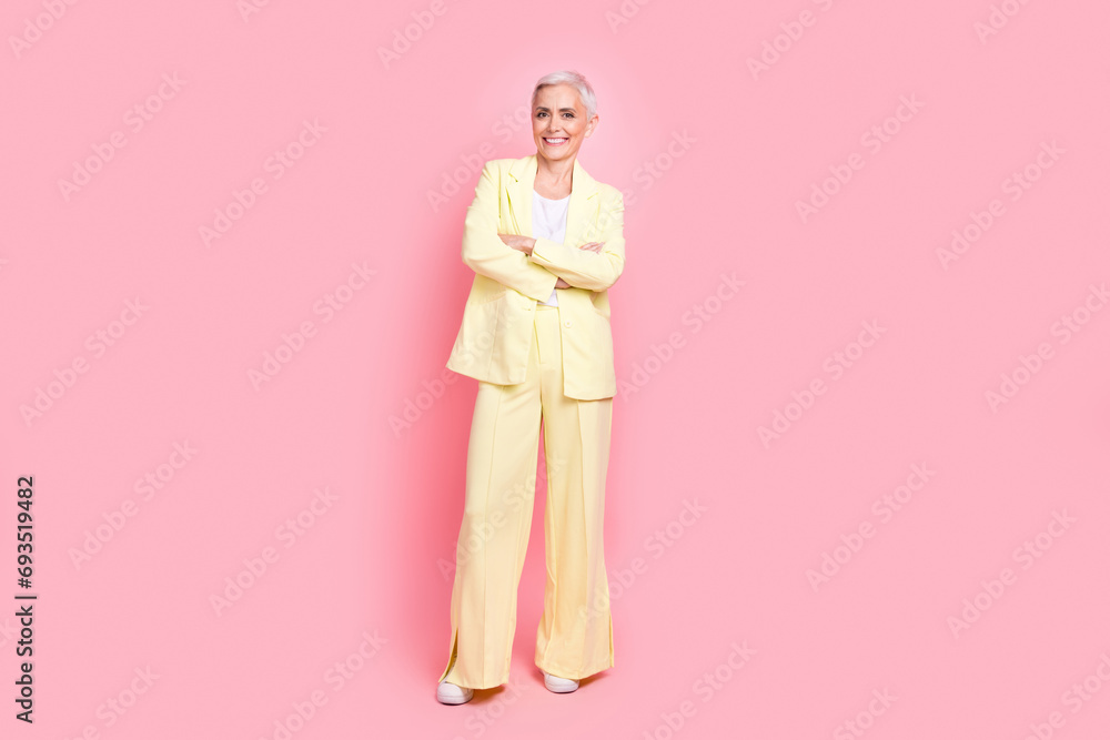 Full body photo of businesswoman yellow suit crossed arms posing at new york times international magazine isolated on pink color background Full body photo of businesswoman yellow suit crossed arms posing at new york times international magazine isolated on pink color background